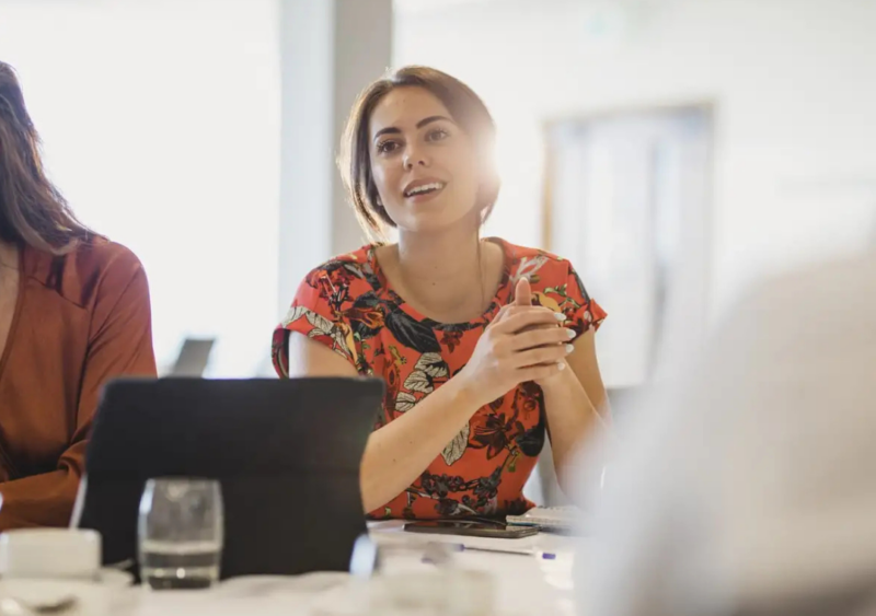 Woman sitting at table, engaged in conversation